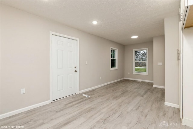 interior space with light hardwood / wood-style floors and a textured ceiling