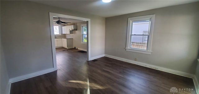 spare room featuring ceiling fan and dark wood-type flooring