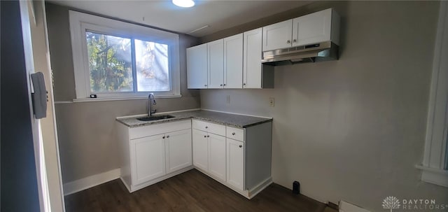 kitchen featuring dark hardwood / wood-style flooring, stone counters, sink, and white cabinets