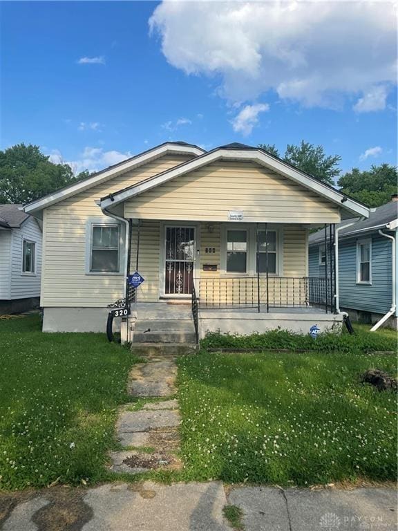 bungalow-style house with a porch and a front lawn