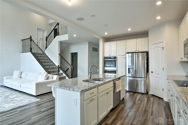 kitchen with a center island with sink, sink, white cabinetry, and stainless steel appliances