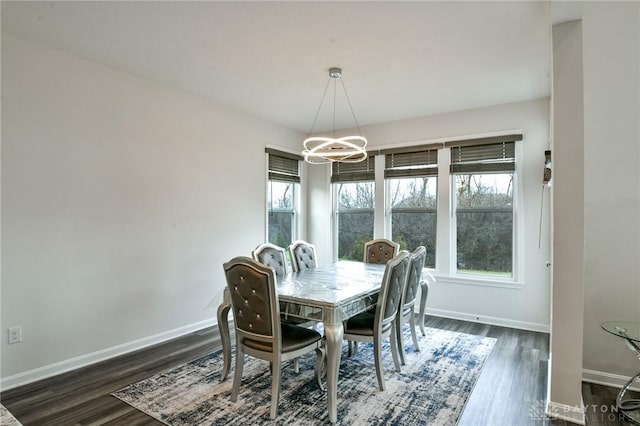 dining area featuring dark hardwood / wood-style floors and an inviting chandelier