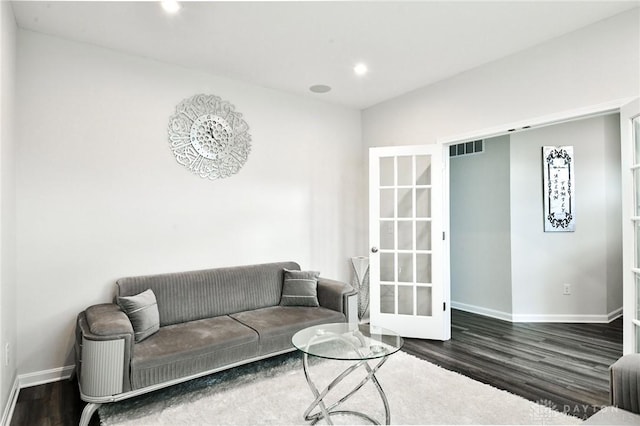 living room with dark hardwood / wood-style flooring and french doors