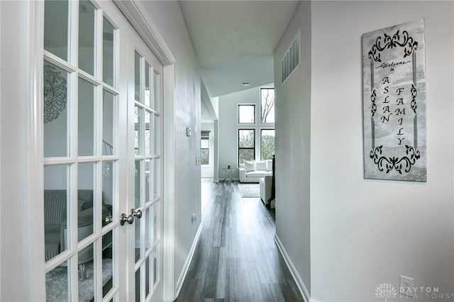 hallway featuring dark hardwood / wood-style flooring, lofted ceiling, and french doors