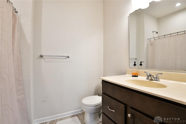 bathroom with a shower with shower curtain, vanity, and toilet