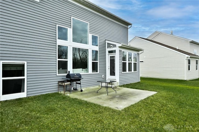 back of house featuring a lawn and a patio