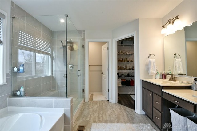 bathroom featuring vanity and independent shower and bath