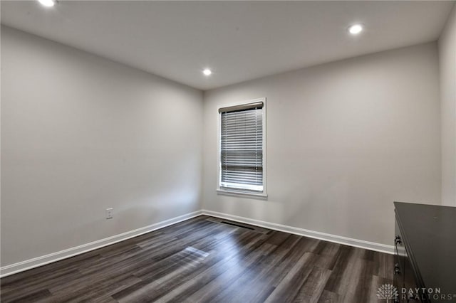 empty room with dark hardwood / wood-style flooring