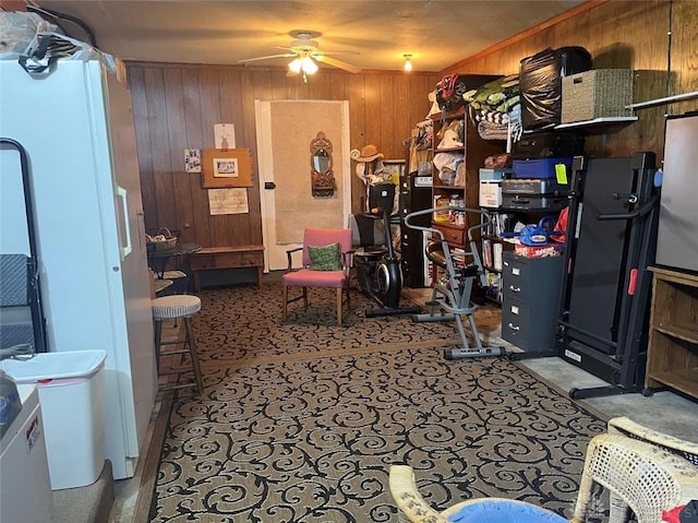 miscellaneous room with ceiling fan and wooden walls