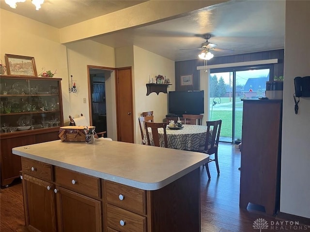 kitchen featuring ceiling fan, a center island, and dark hardwood / wood-style flooring