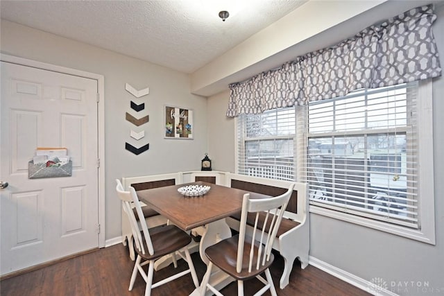 dining space with dark hardwood / wood-style flooring and a textured ceiling