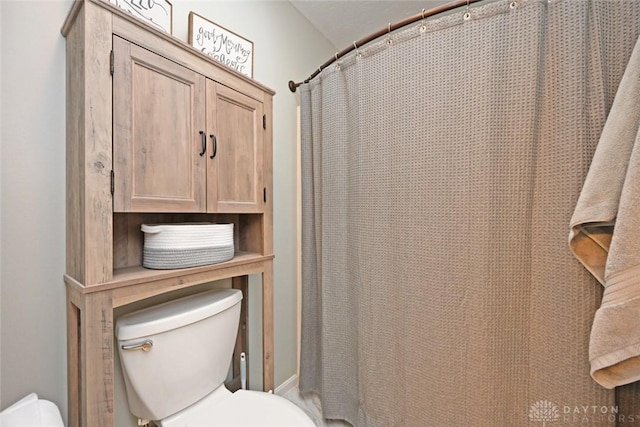 bathroom featuring a shower with curtain and toilet