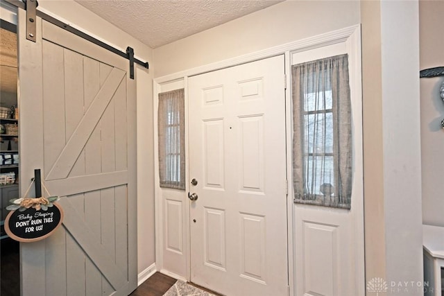 foyer entrance with a textured ceiling and a barn door