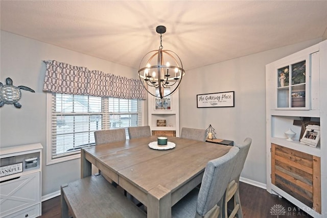 dining room with dark hardwood / wood-style floors and an inviting chandelier