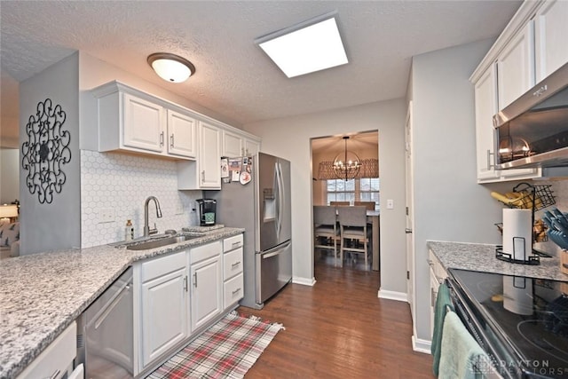 kitchen featuring sink, white cabinets, a notable chandelier, and appliances with stainless steel finishes