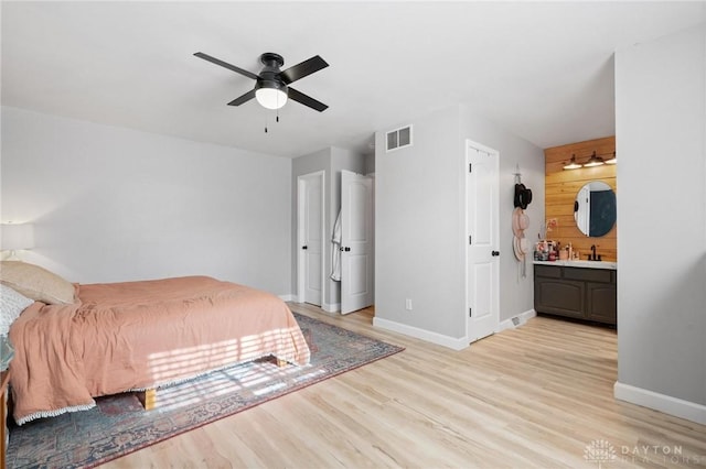 bedroom featuring ensuite bathroom, light wood-type flooring, sink, and ceiling fan