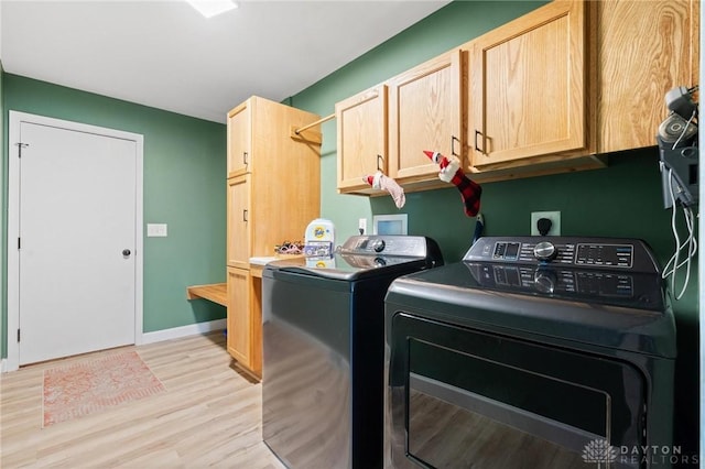 washroom with cabinets, separate washer and dryer, and light wood-type flooring