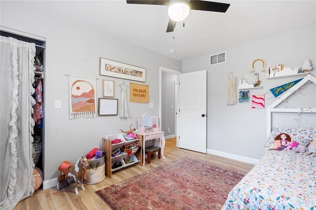 bedroom with hardwood / wood-style flooring, ceiling fan, and a closet