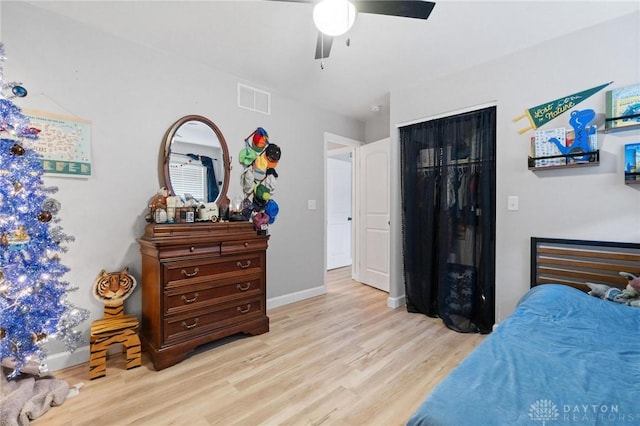 bedroom with light wood-type flooring, ceiling fan, and a closet