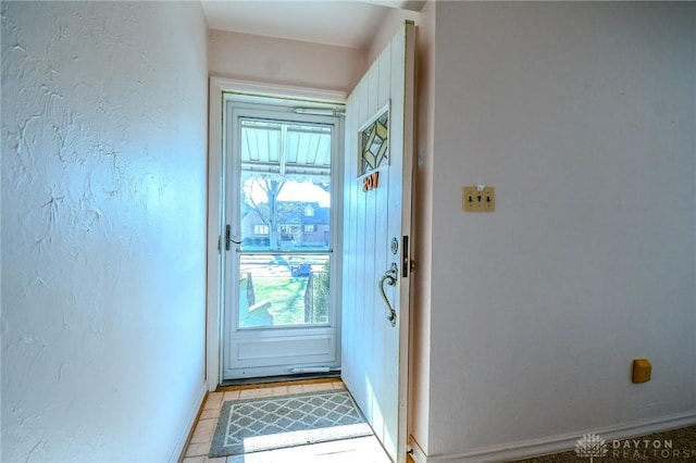 doorway to outside with light tile patterned flooring