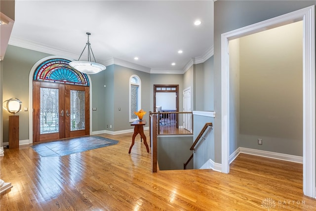 entryway featuring hardwood / wood-style floors, crown molding, and french doors