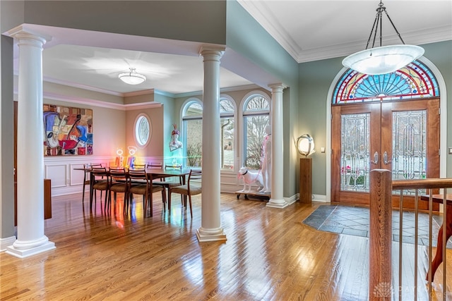 entryway with wood-type flooring, crown molding, and french doors