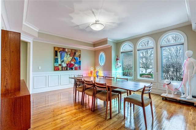 dining area with light hardwood / wood-style floors and crown molding