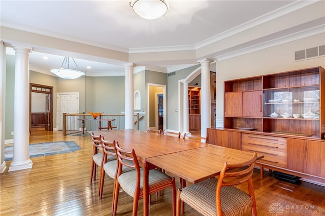 dining area featuring wood-type flooring and ornamental molding