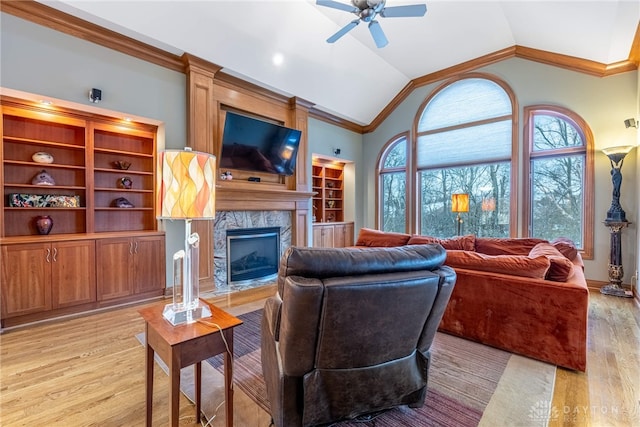 living room with ornamental molding, ceiling fan, light hardwood / wood-style flooring, lofted ceiling, and a tiled fireplace