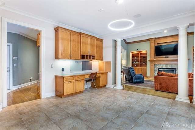 kitchen with a high end fireplace, built in desk, and ornamental molding