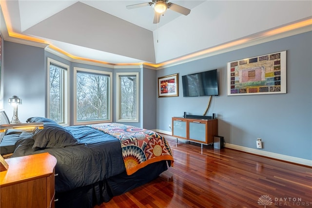 bedroom with ceiling fan, dark hardwood / wood-style floors, a raised ceiling, and ornamental molding