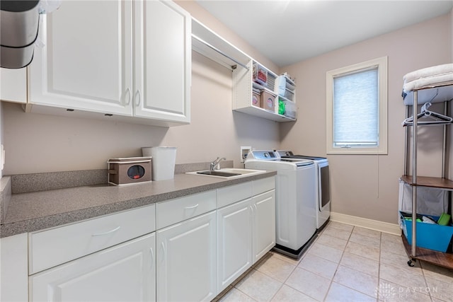 laundry room featuring sink, light tile patterned floors, cabinets, and independent washer and dryer