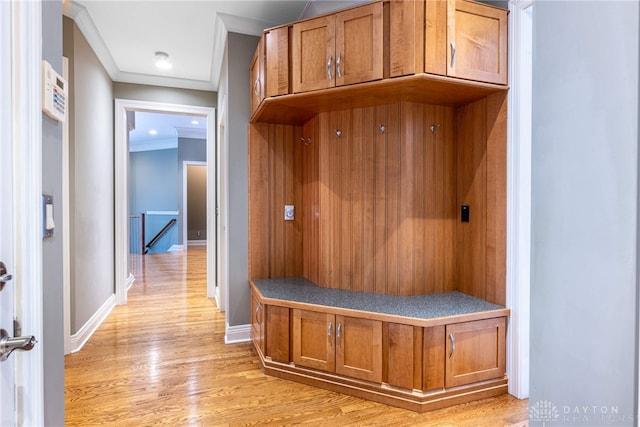 mudroom with light wood-type flooring and crown molding