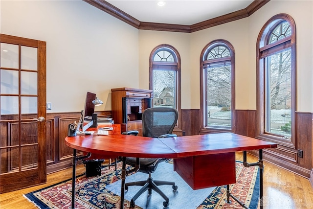 home office with light hardwood / wood-style flooring, a wealth of natural light, and ornamental molding