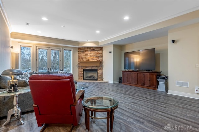 living room featuring a fireplace, dark hardwood / wood-style floors, and ornamental molding