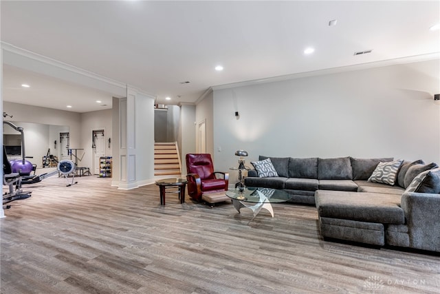 living room with crown molding and light hardwood / wood-style flooring