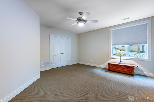 unfurnished bedroom featuring carpet, a closet, and ceiling fan