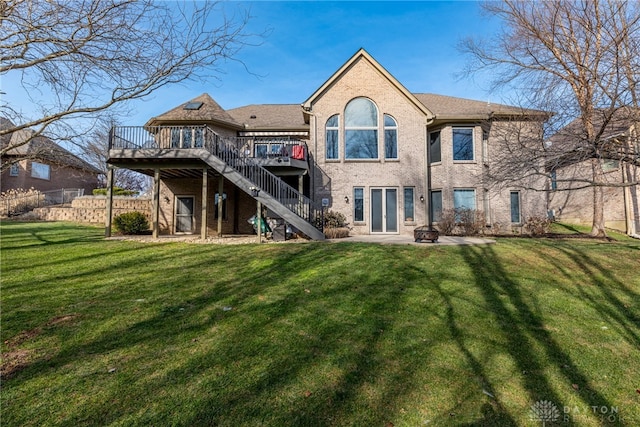 back of house with an outdoor fire pit, a lawn, and a wooden deck