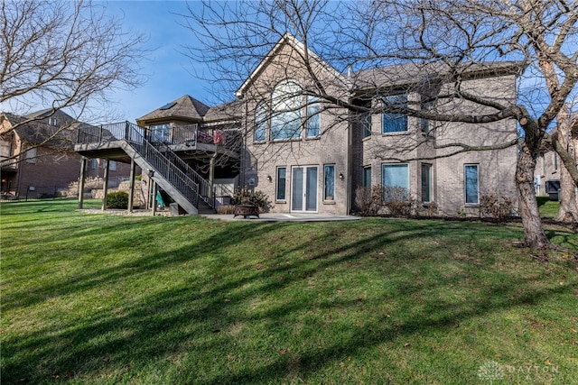 rear view of house featuring a wooden deck and a yard