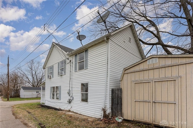 view of side of home featuring a storage shed