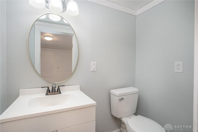 bathroom with vanity, ornamental molding, and toilet