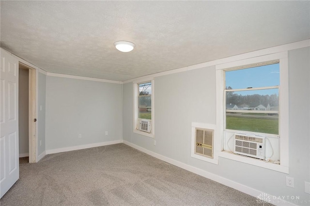 carpeted empty room with cooling unit, heating unit, and a textured ceiling