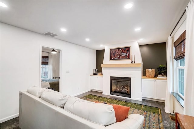 living room featuring ceiling fan and a fireplace