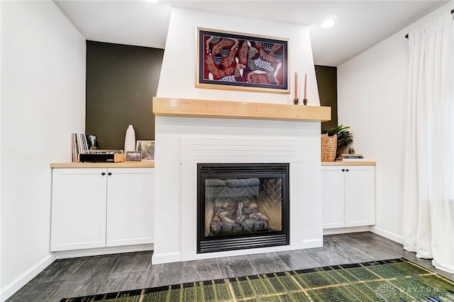 interior details featuring hardwood / wood-style flooring and a large fireplace