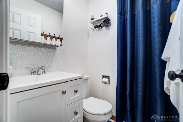 bathroom with tasteful backsplash, vanity, and toilet