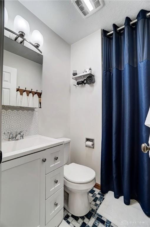 bathroom featuring decorative backsplash, vanity, and toilet