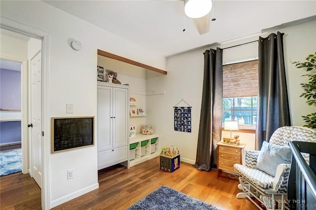 sitting room featuring ceiling fan and dark wood-type flooring