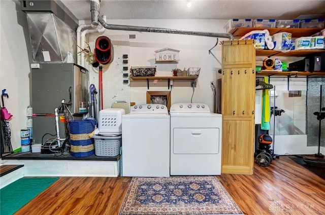 laundry area with washing machine and dryer and hardwood / wood-style floors