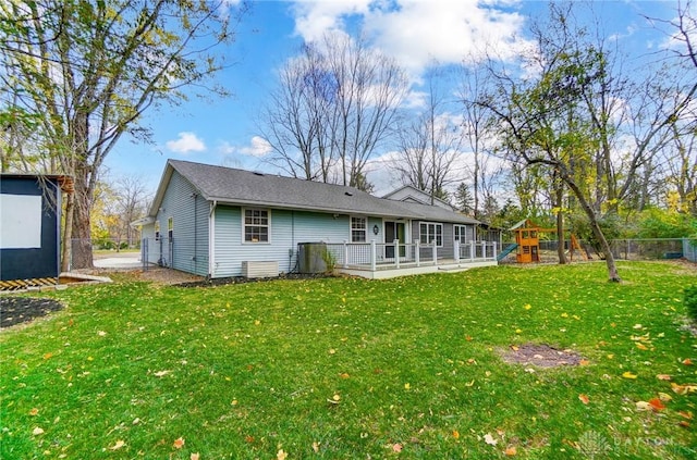 rear view of house with a playground and a yard