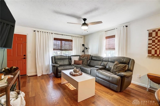 living room with hardwood / wood-style floors, a textured ceiling, and ceiling fan